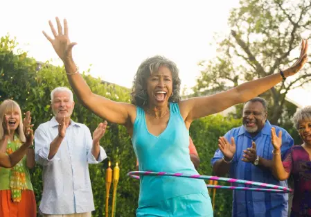 A woman hula hooping in front of some people.