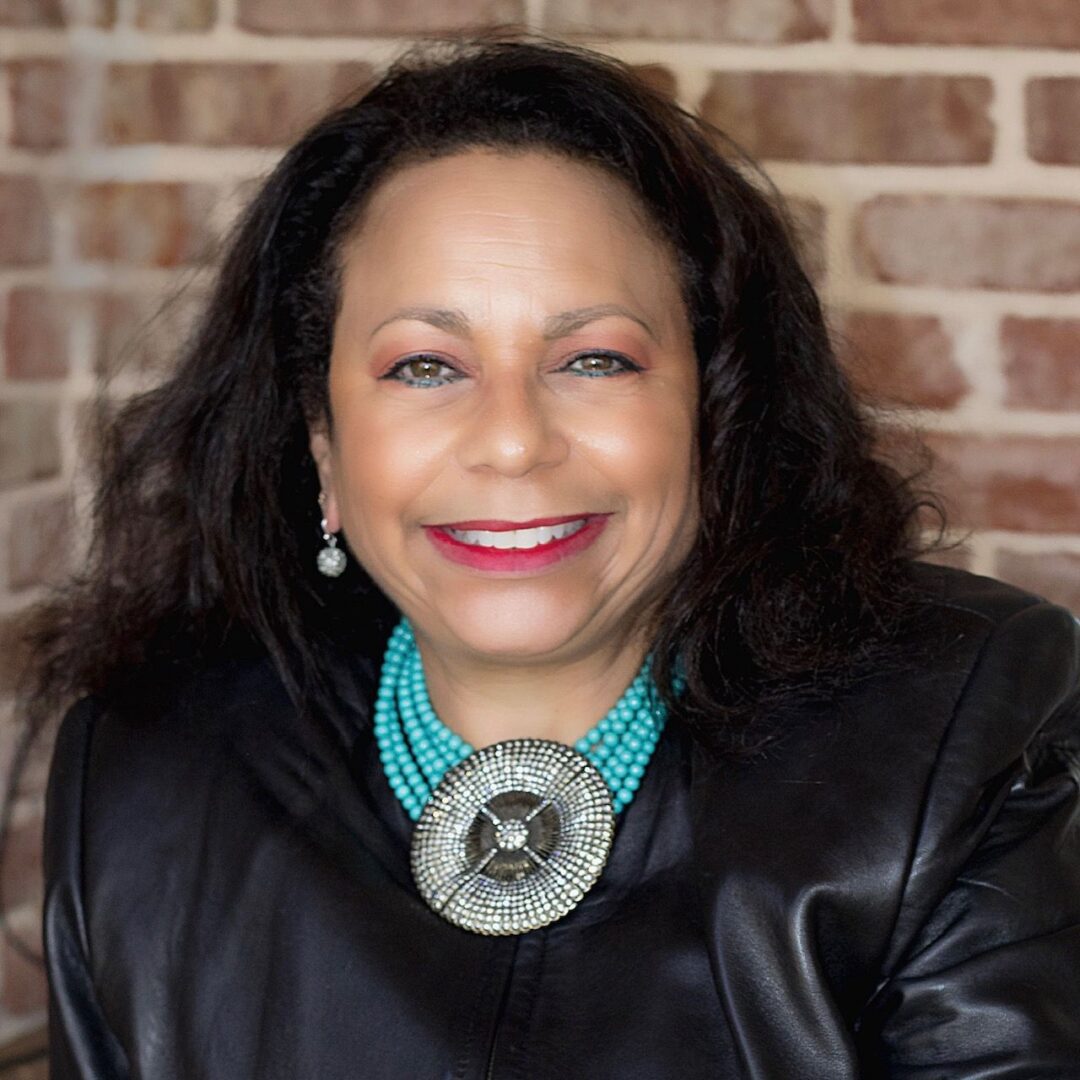 A woman wearing a leather jacket and necklace.